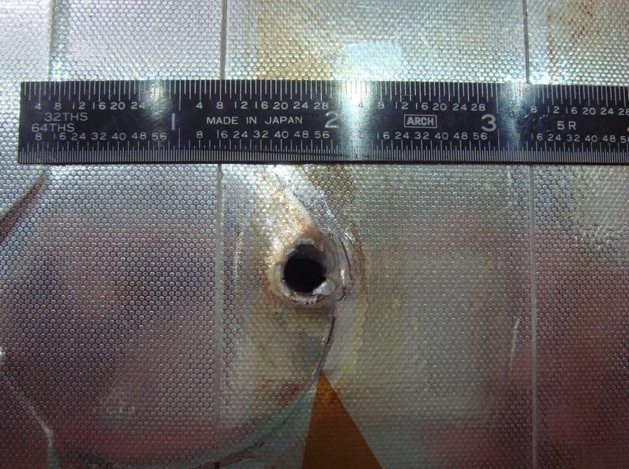 Сквозное отверстие в радиаторной панели шаттла  «Индевор», оставшееся после столкновения  с куском мусора