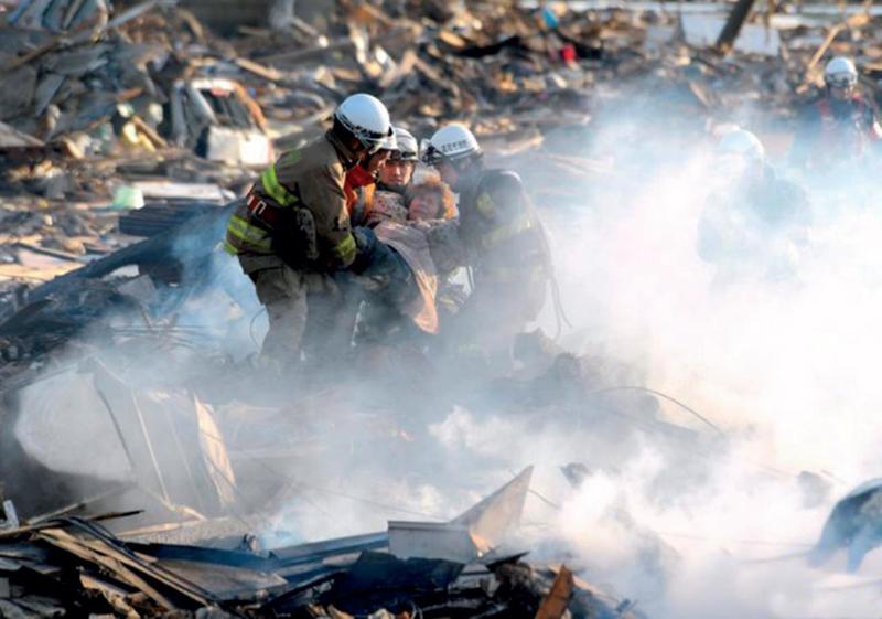 последствия землетрясения, спасатели вытаскивают человека, обломки здания