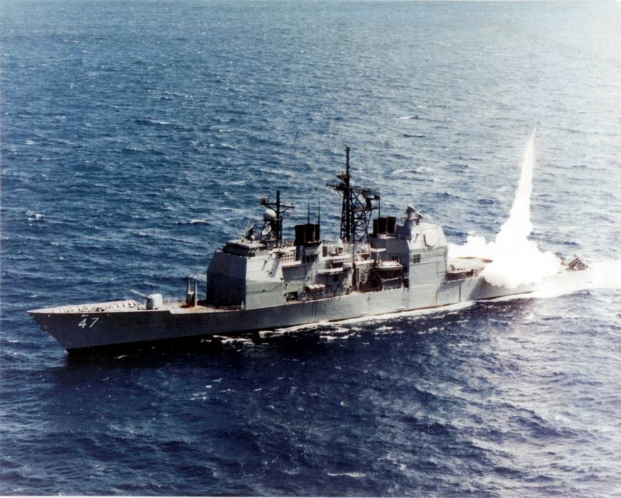 Американский Крейсер УРО «Тикондерога» (USS Ticonderoga, CG 47) производит стрельбу зенитной ракетой «Стандарт» SM-2MR из универсальной установки вертикального пуска Mk.41 на корме корабля – 1986 г. 