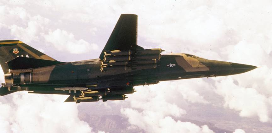 Американский сверхзвуковой тактический ударный самолет с крылом изменяемой стреловидности Дженерал Дейнемикс F-111A с внешней подвеской из шестнадцати бомбовых кассет, каждая из которых весит 180 кг
