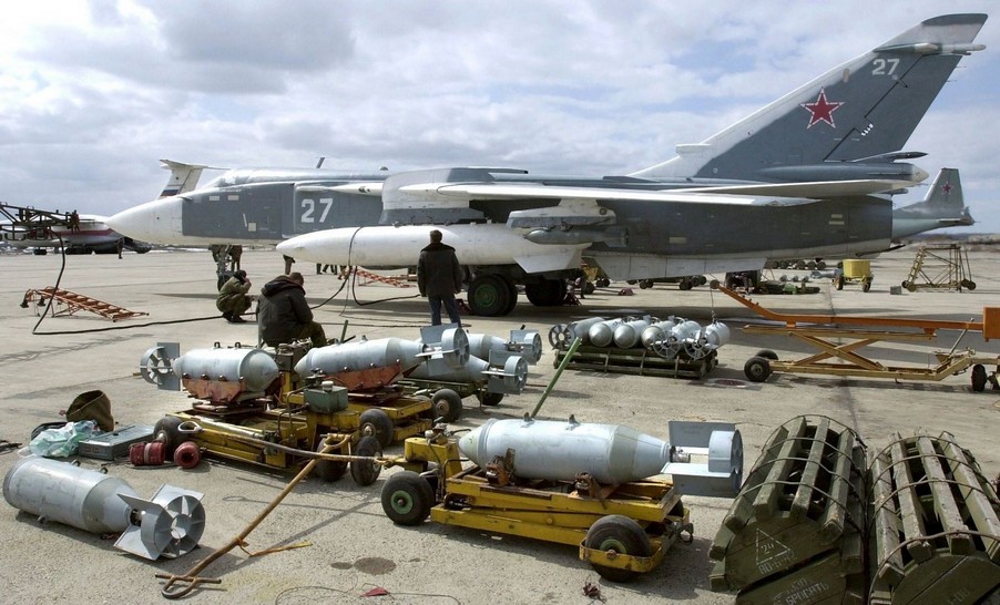 Подготовка к подвеске неуправляемых толстостенных фугасных бомб ФАБ-250ТС на бомбардировщик Су-24М ВКС РФ на авиабазе Хмеймим в Сирии (на его крыльевых держателях уже подвешены бомбы ФАБ-250М62)
