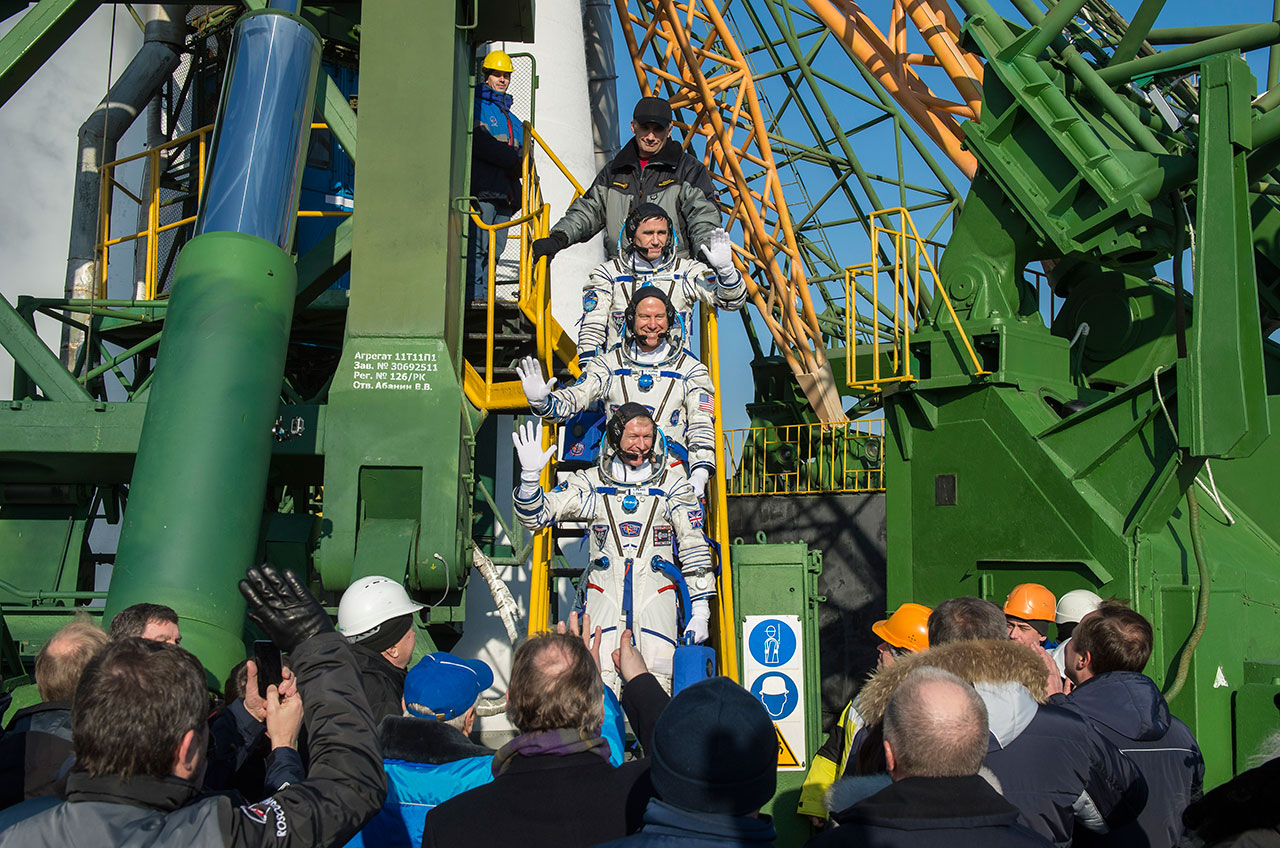 Экипаж МКС-46/47 фотографируется на лифте «Гагаринского старта» перед тем как занять места в корабле "Союз ТМА-19М". Сверху вниз: Юрий Маленченко (Россия), Тимоти Копра (США) и Тимоти Пик (Англия)